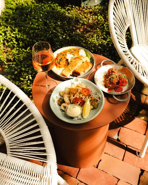 Shot of calamari, wine, meatballs, and dip on outdoor table