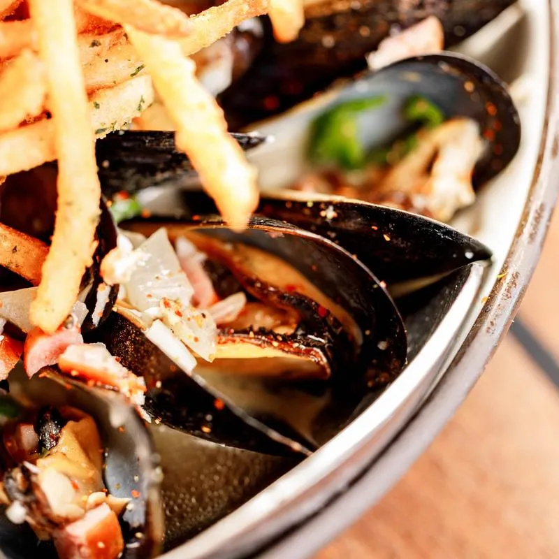A close-up of Moules Frites dish.