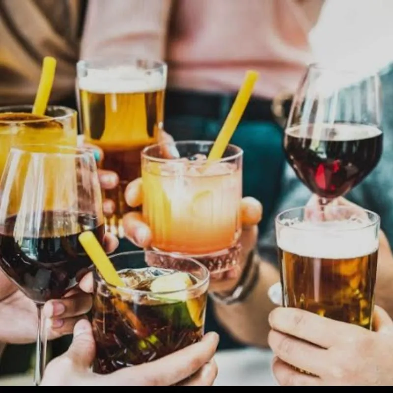 Different cocktail, beer and vine gllases put together in a toast.