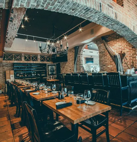Charming restaurant interior with brick walls, wooden tables, and stylish lighting.