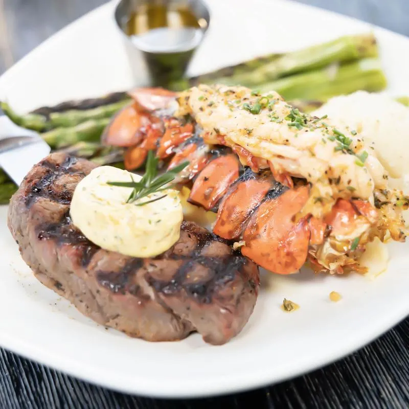 Steak and lobster served with asparagus and mashed potatoes.