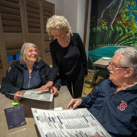A couple at a table interacting with a server.