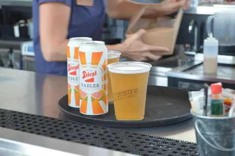 Cans and beer glasses on bar counter.