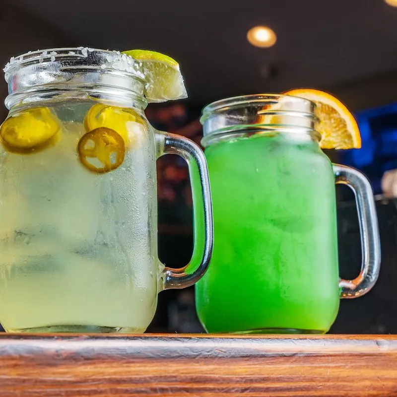 Two cocktails with jalapenos and citrus.