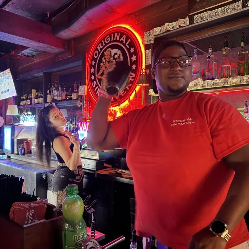 Bartender shaking a cocktail behind a bar counter.
