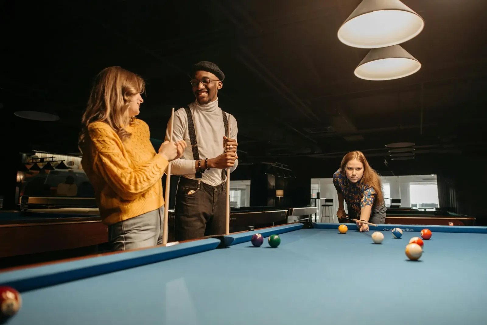 three people playing pool