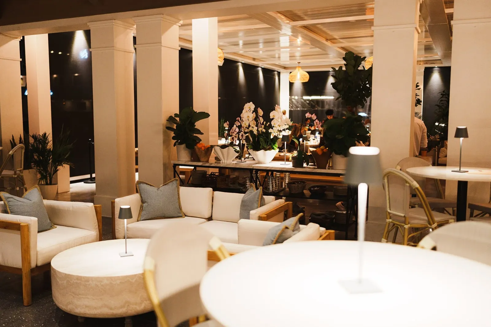 Elegant lounge area at Lamarina waterfront restaurant in West Palm Beach featuring white sofas, ambient lighting, and lush greenery creating a sophisticated coastal dining atmosphere, best Restaurant 