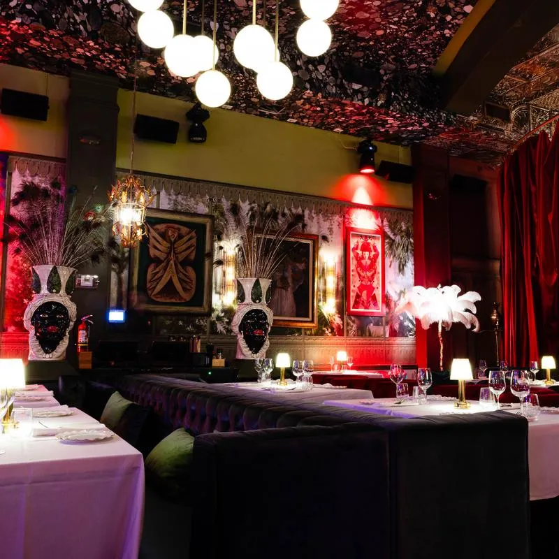 Dining room interior with artwork and lighting fixtures.