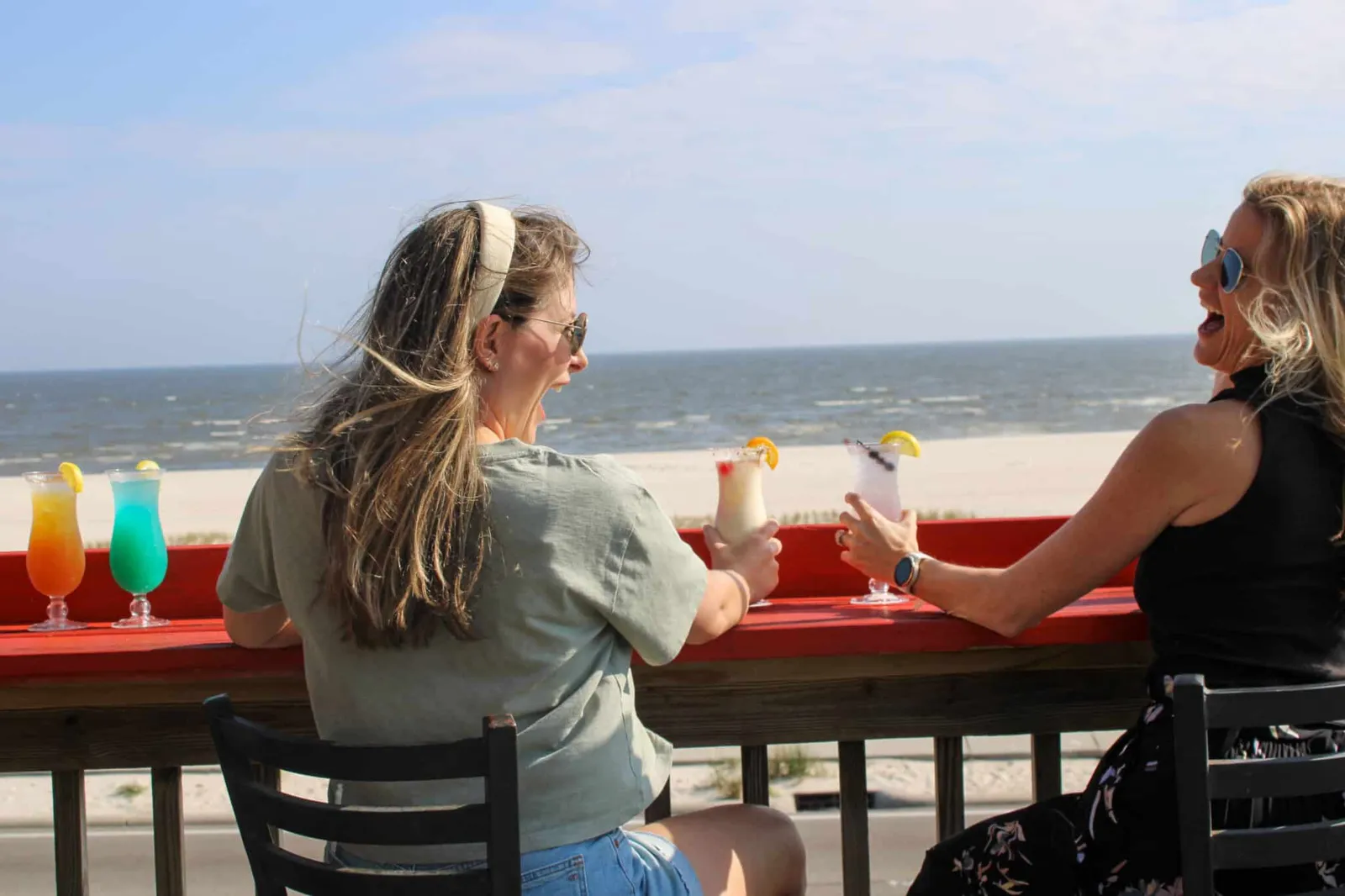 Friends sitting at the bar overlooking the Gulf of Mexico at Shaggy's Gulfport Beach