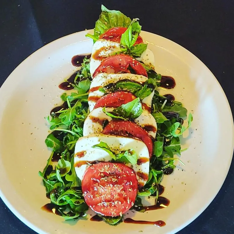 Caprese salad with mozzarella, basil tomatoes, and balsamic vinaigrette.