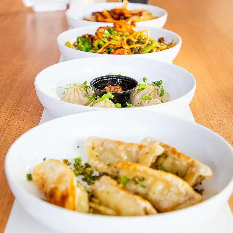 Assorted food bowls lined up on a table.
