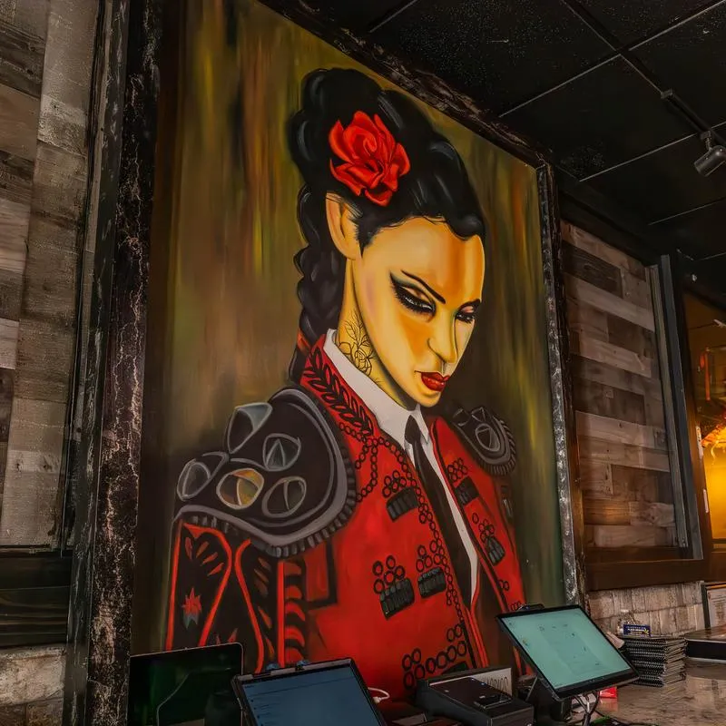 Framed paiting of a women dressed as a toreador.