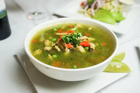 A bowl of soup with meat and vegetables.