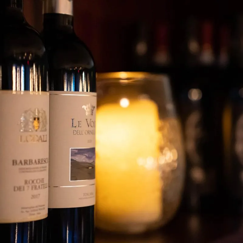 Different wine bottles, light candle in a jar