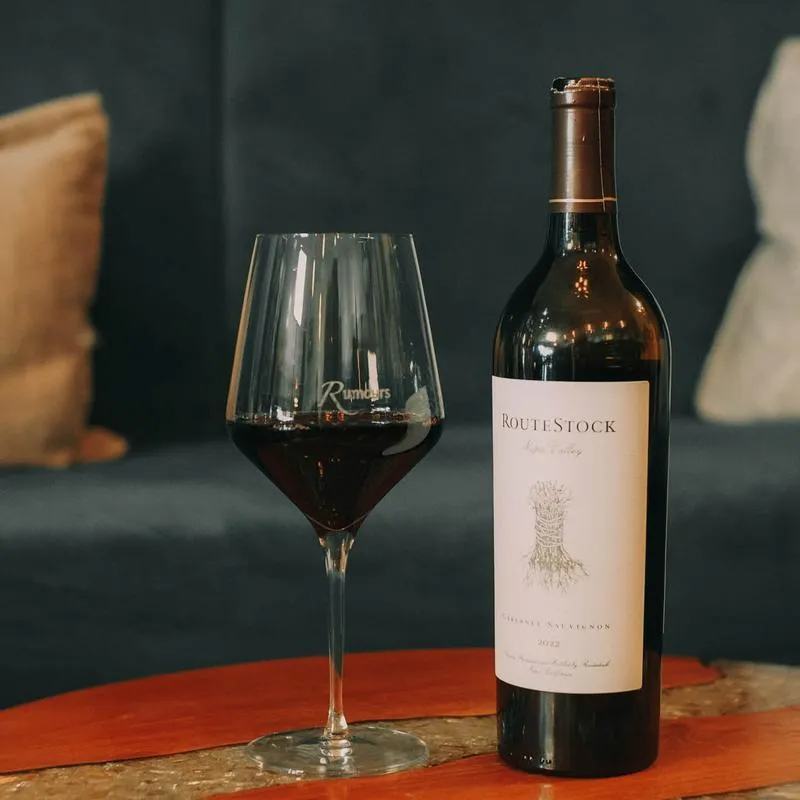 Glass of red wine and a bottle on the table