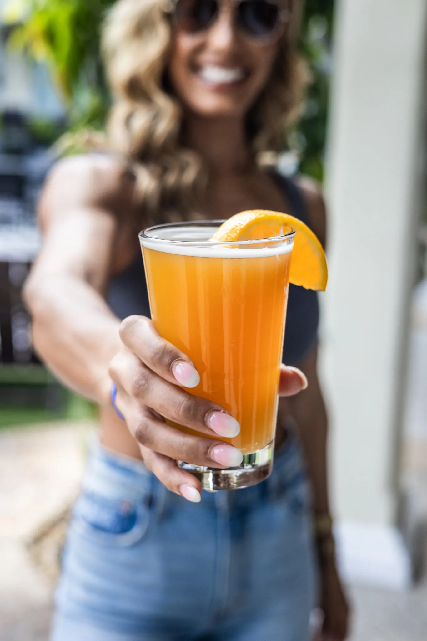 Hand holding glass of orange juice with slice