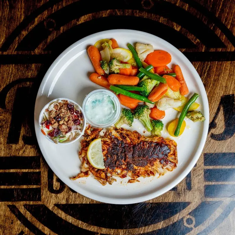 Grilled seasoned fish with mixed vegetables and coleslaw.