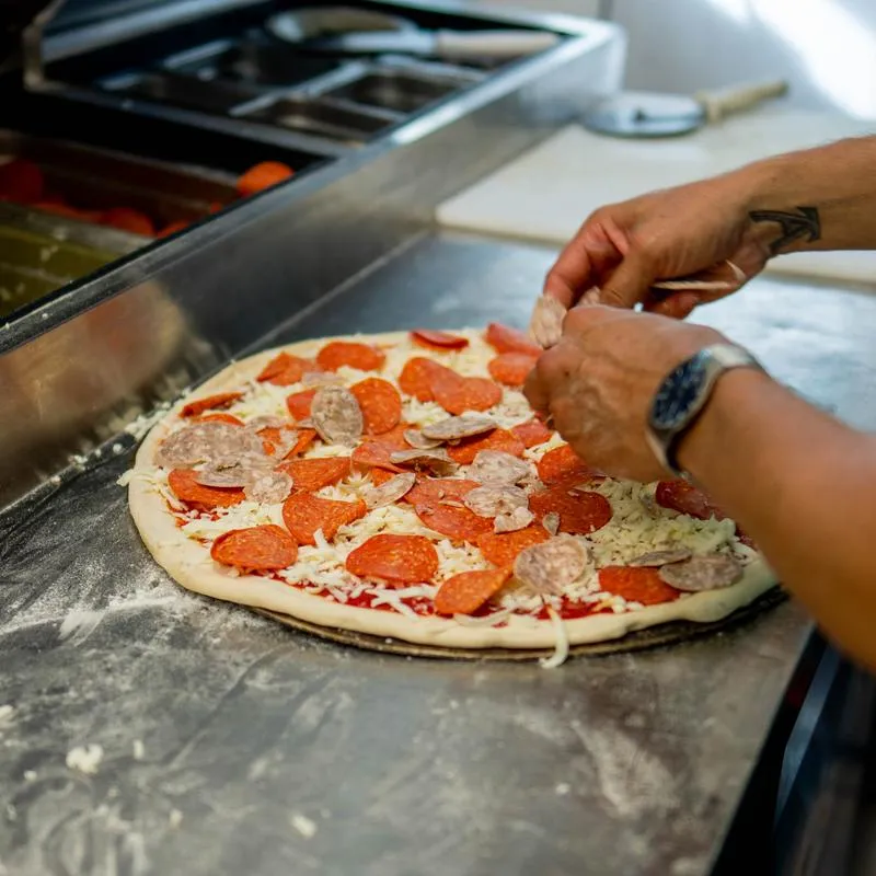 Pizza being prepared on the kitchen counter.