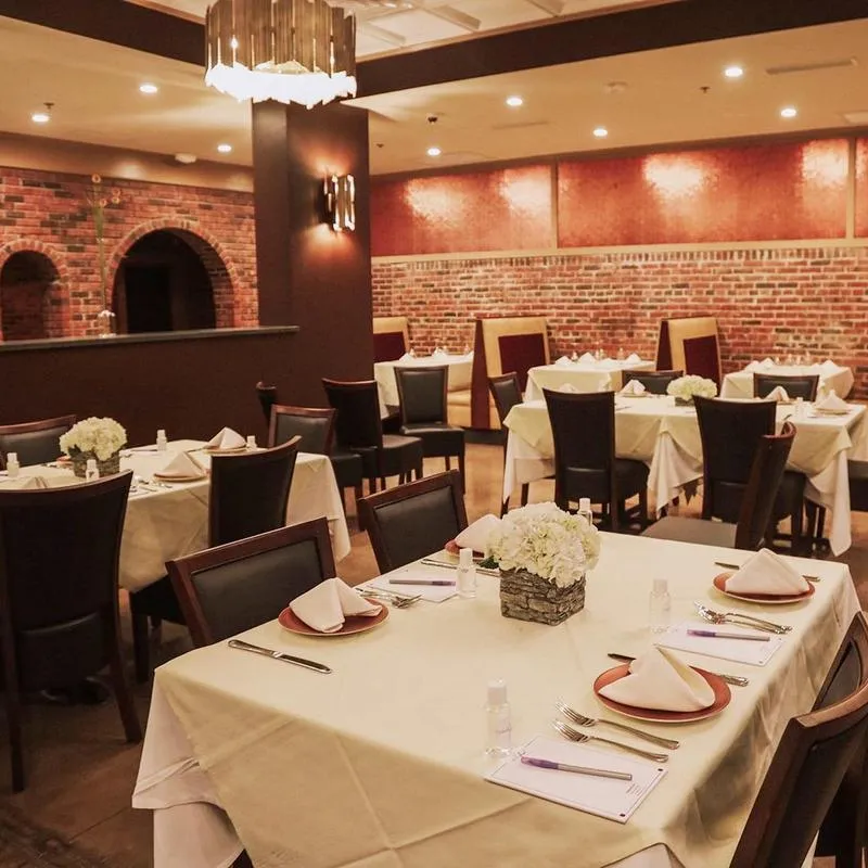 restaurant tables decorated for an event, with floral arrangements, and linens.