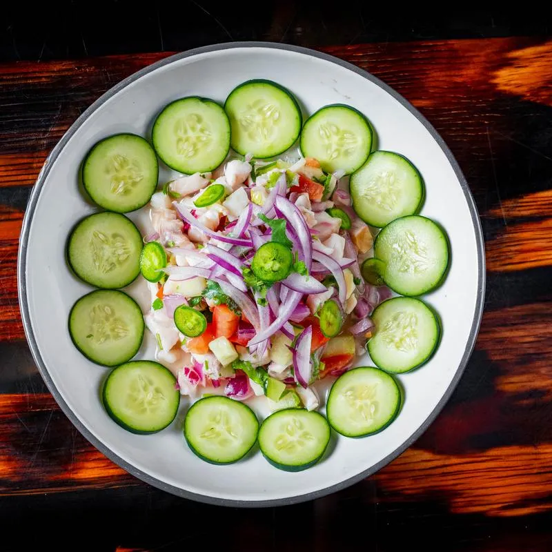 Cevivhe with sliced red onions, salt, cucmbers and chili peppers.