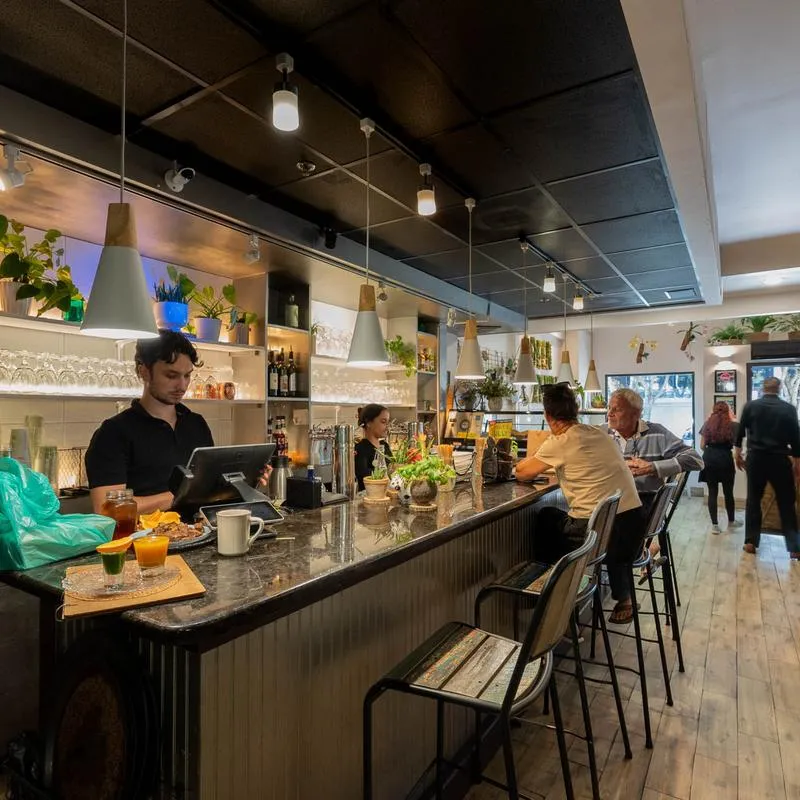 A calm cafe interior design with patrons enjoying drinks at the bar.