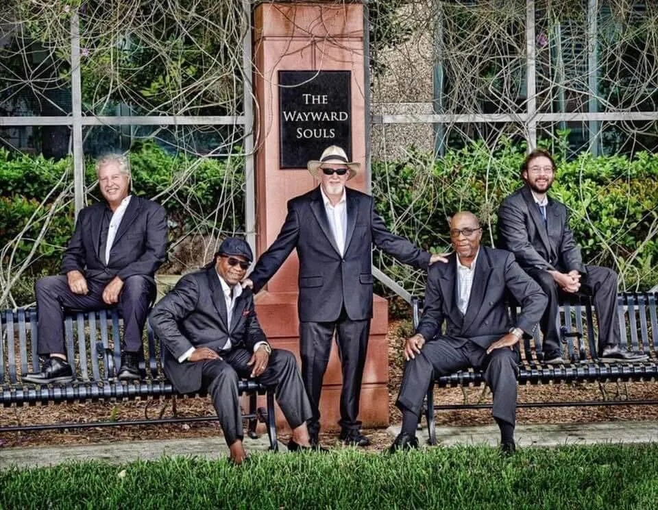 A group of men sitting on top of benches.