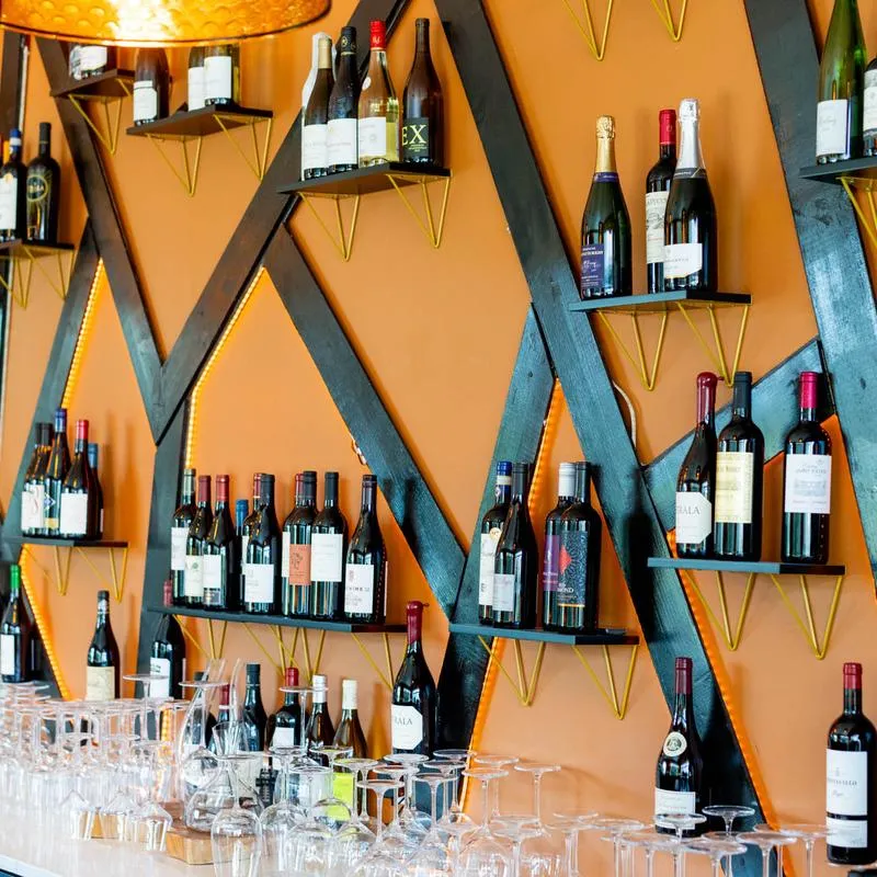 Wine bar details, glassware and wine bottles.
