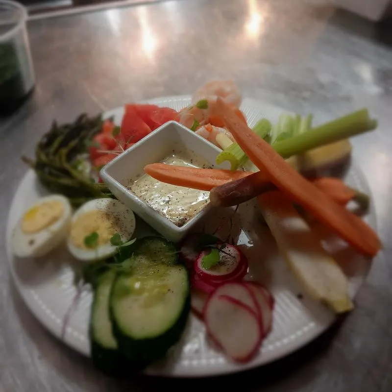 Vegetable assortment served with a dipping sauce and a boiled egg.