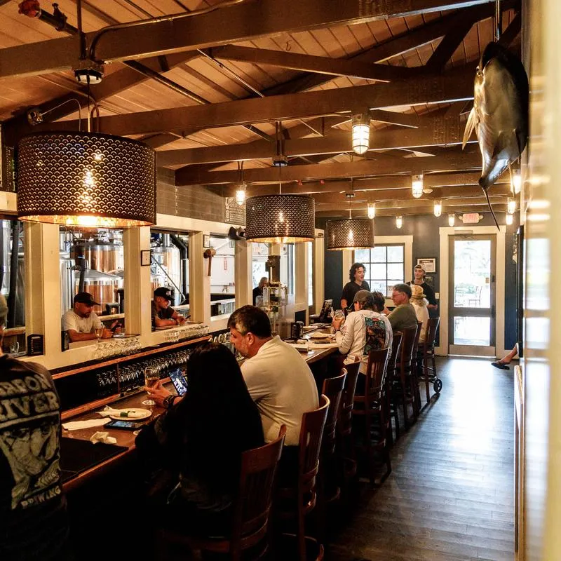 People dining at the long wooden bar counter.