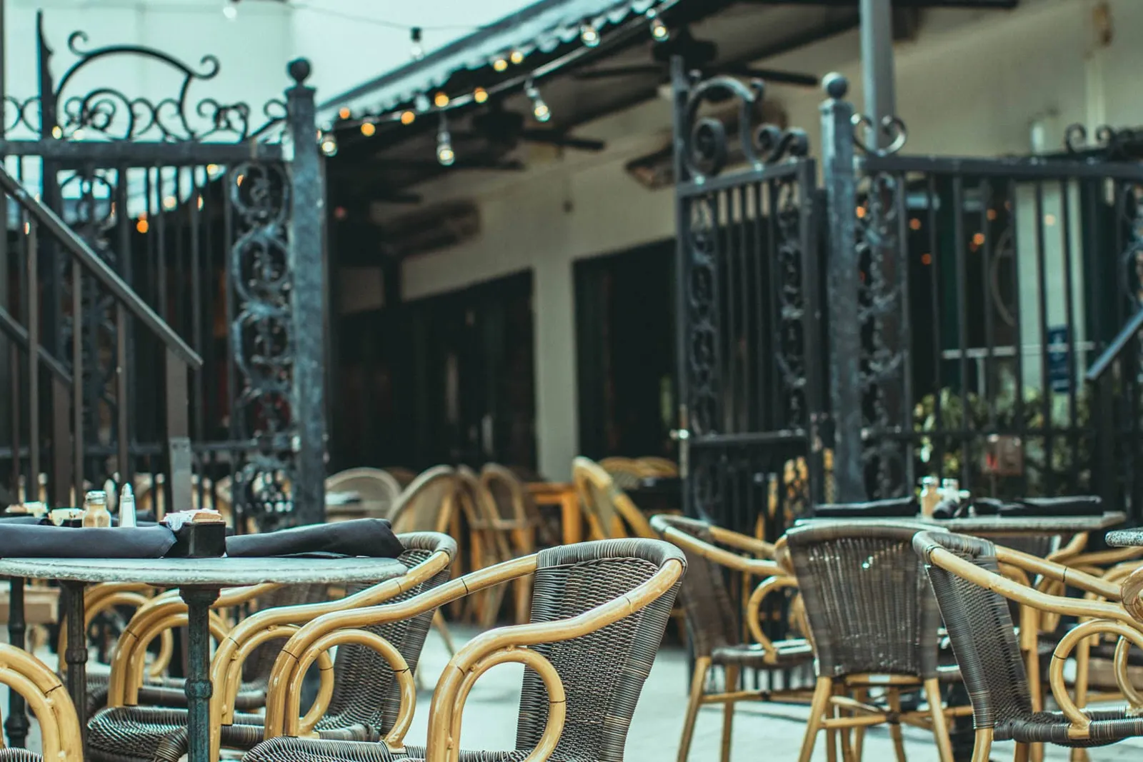 Outdoor dining area at Boheme Bistro with stylish wicker chairs and tables.