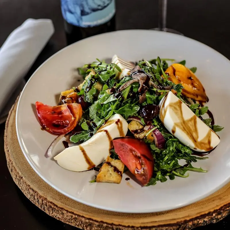 Arugula salad, with cheese, tomatoes, croutons, and balsamic vinaigrette.