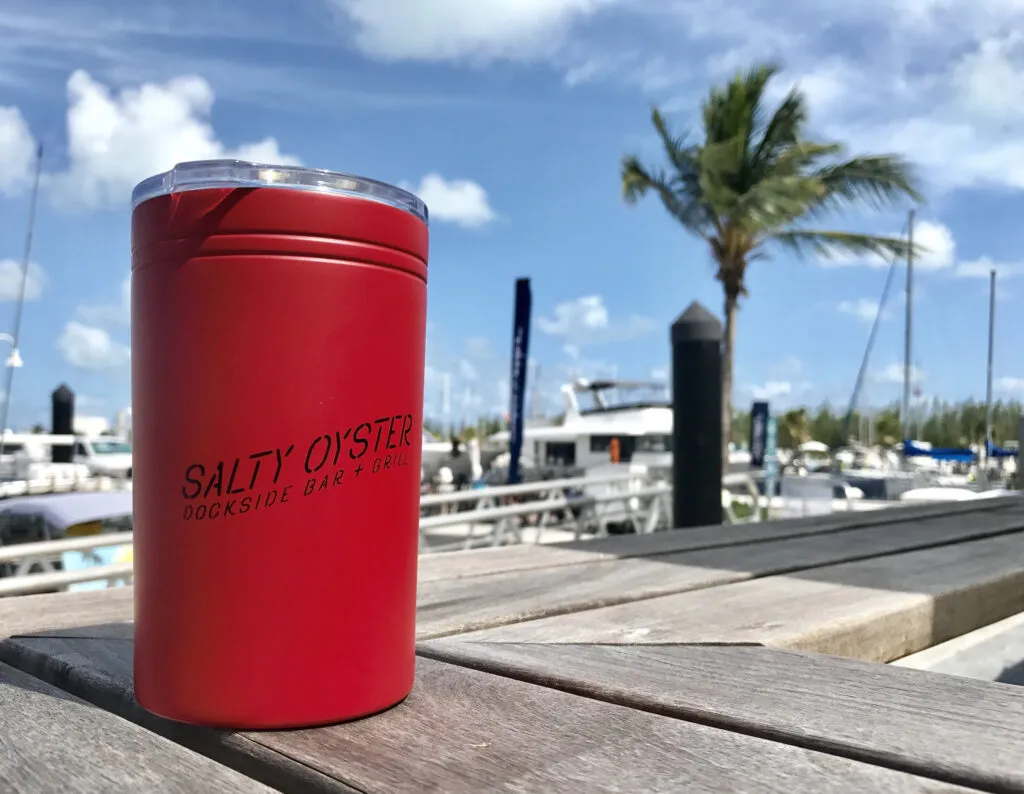 Red Salty Oyster tumbler on dockside table.