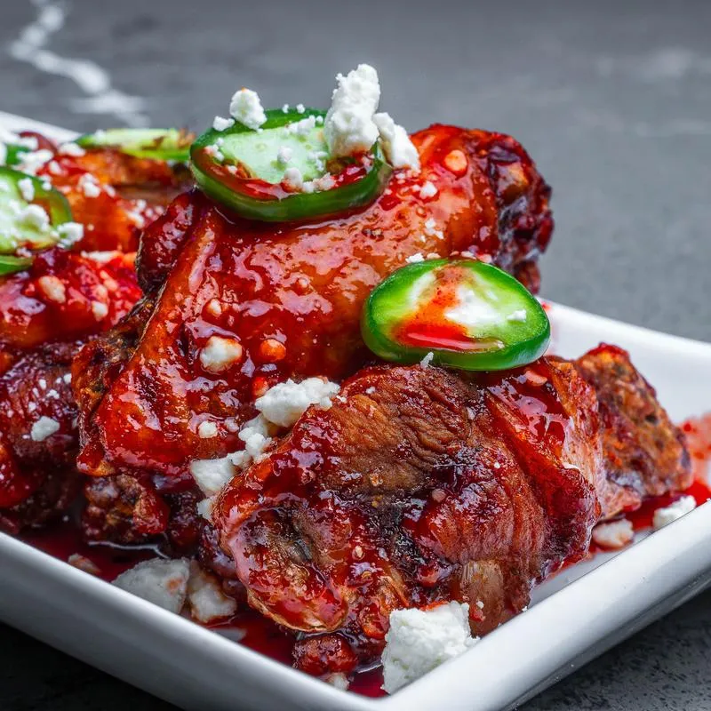 Glazed chicken wings topped with jalapenos and crubled cheese.