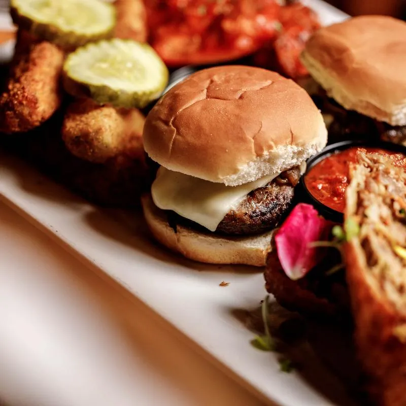Appetizer sampler featuring burger sliders, mozzarella sticks, and eggrolls.