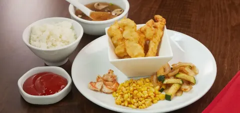 Kabuki kids' meal with tempura chicken, grilled shrimp, corn, sautéed vegetables, white rice, ketchup, and a bowl of soup.