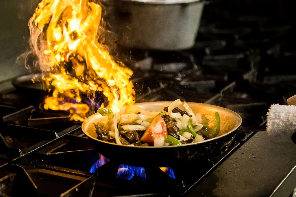 Flaco's fajita - beef, chicken and shrimp served sizzling with green peppers, onions, tomatoes, guacamole, sour cream, flour tortillas, rice and refried beans. House made and marinated