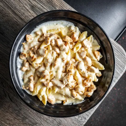 Chicken Alfredo Pasta featuring penne pasta and chicken in creamy sauce.
