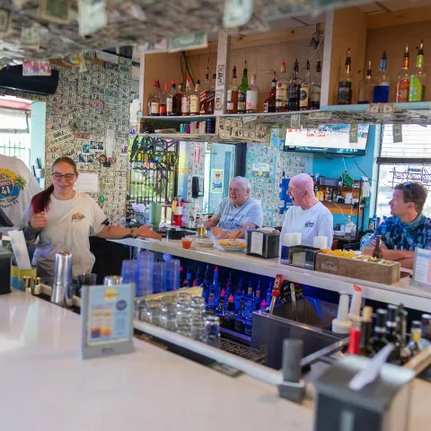Interior, bartender and seated guests.