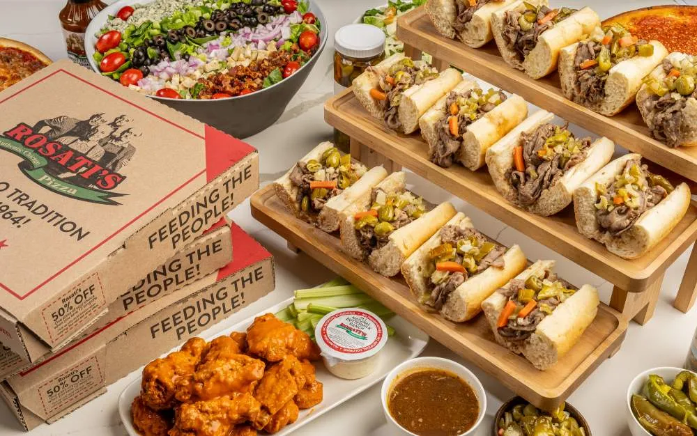 Rosati’s catering spread with sandwiches, salad, jumbo wings and pizza boxes