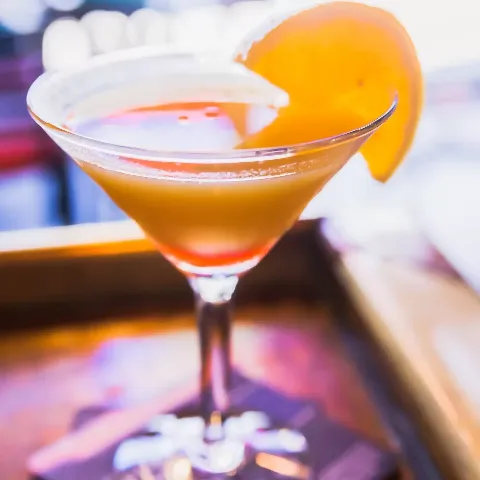 Craft cocktail in a martini glass with an orange slice garnish served at the bar at Bogey's Sports Pub in Venice, FL