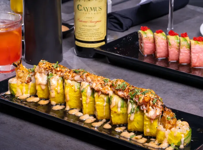 A bottle of red wine beside sushi rolls at KamiKoi
