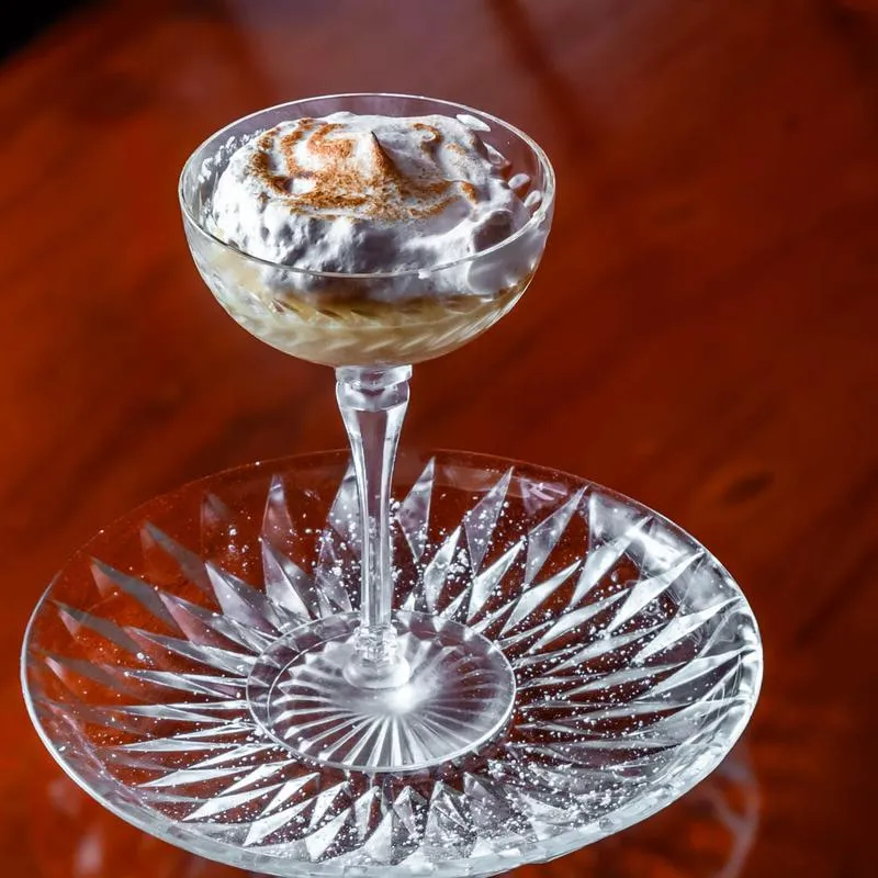 Creamy dessert with whipped topping and cinnamon dusting in a coupe glass.