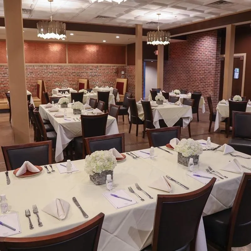 A restaurant dining room set up for a wedding event. Decorated tables..