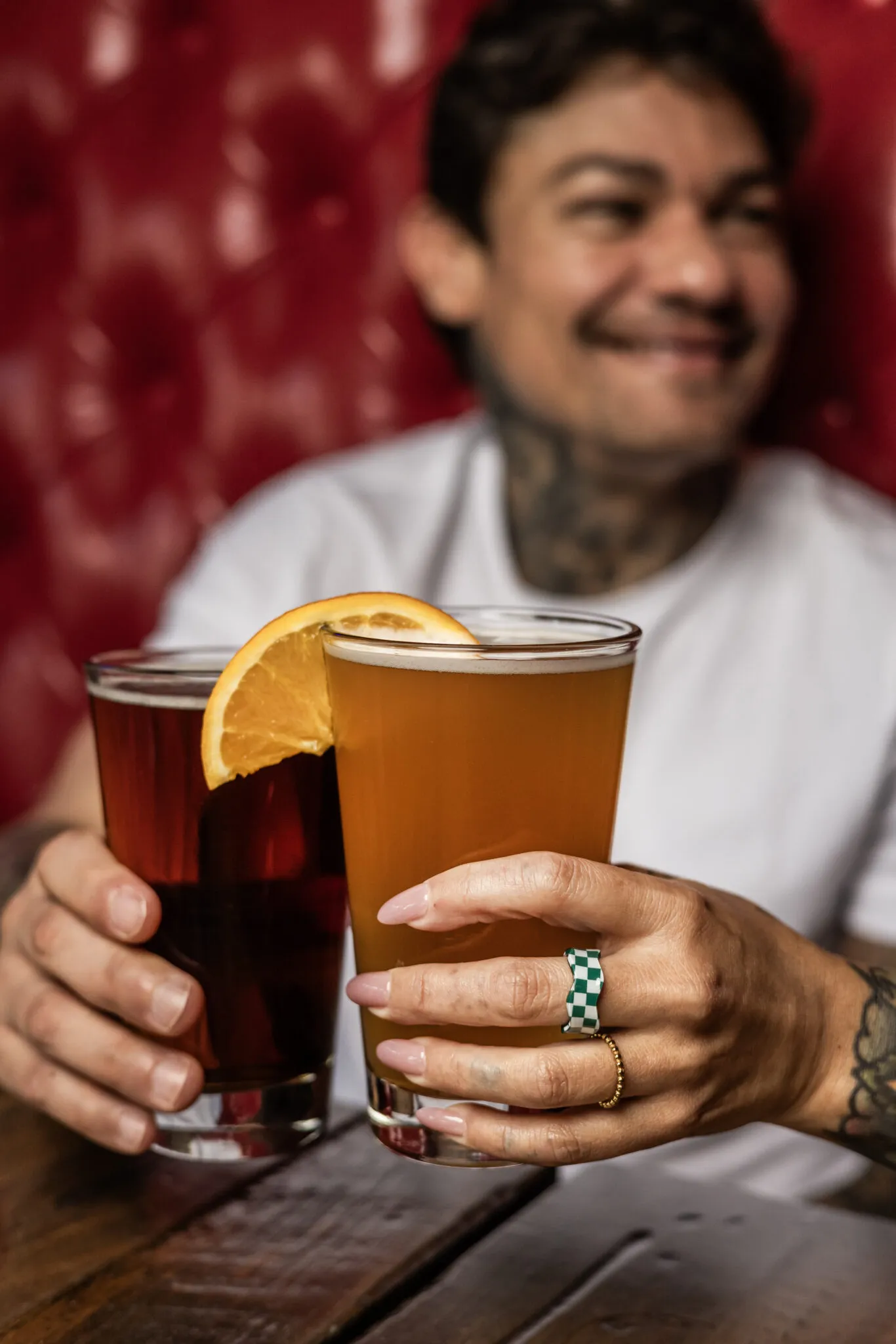 Smiling person holding two craft beers