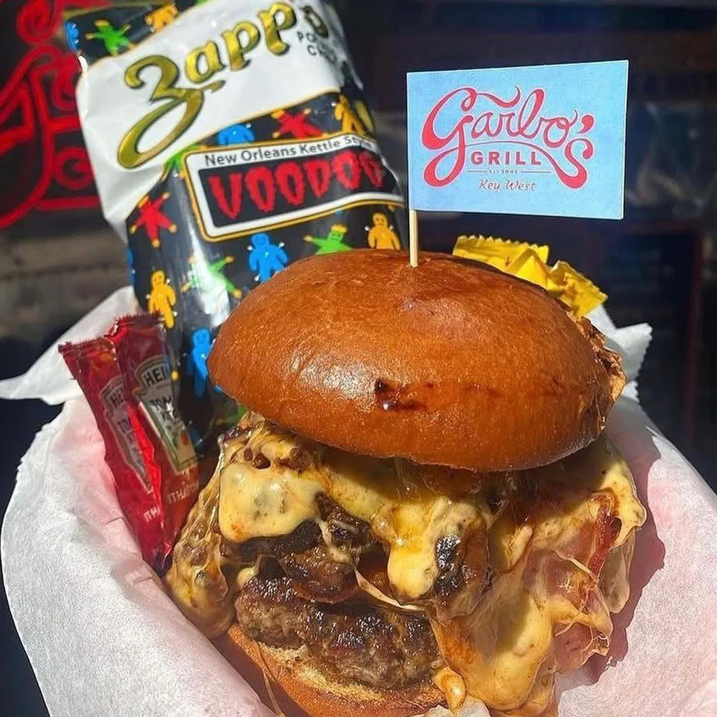 Cheeseburger with a brioche bun, served with Voodoo chips, pickles, and ketchup at Garbo's Grill.
