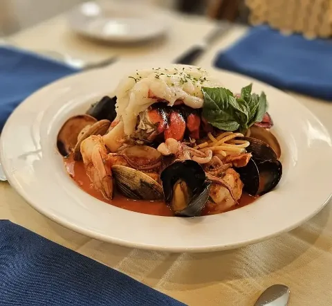 Frutti di Mare — house-made pasta with lobster, shrimp, clams, mussels, and calamari in a spicy tomato broth