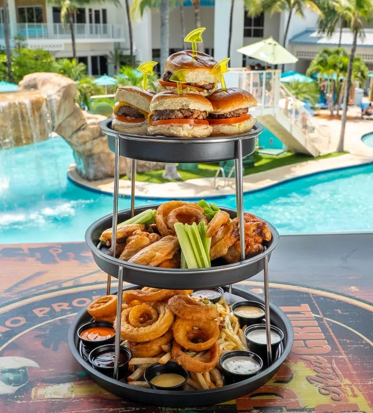 A Couple Of Trays Of Food By A Pool