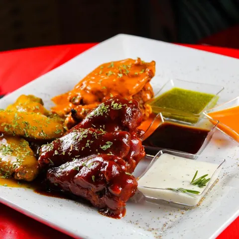 Buffalo chicken wings with barbecue, hot, and honey mustard sauces.