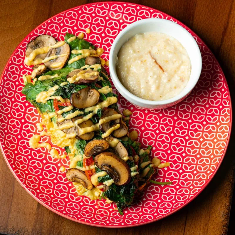 Spinach and mushroom omelet served with creamy grits.