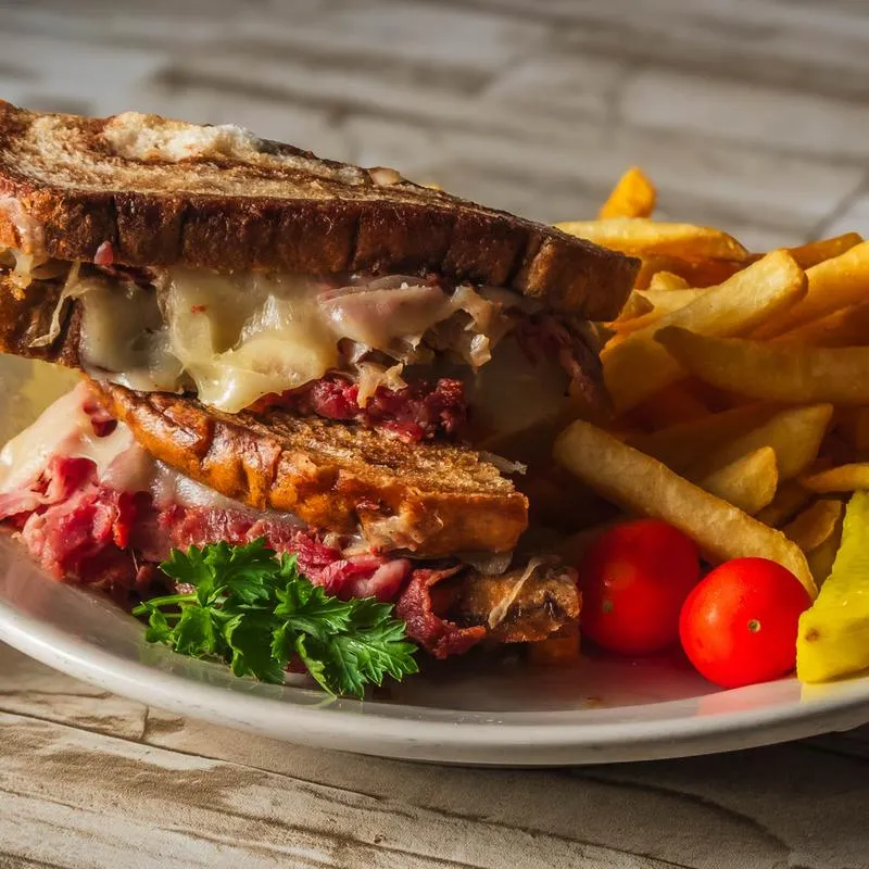 Reuben sandwich with fries and cherry tomatoes.